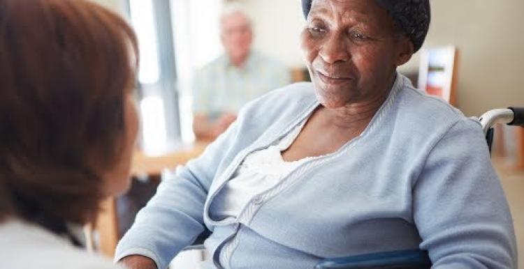 Black elderly woman in a nursing home talking to a nurse