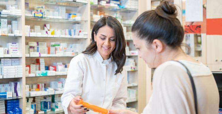Pharmacist assisting a female customer at the counter