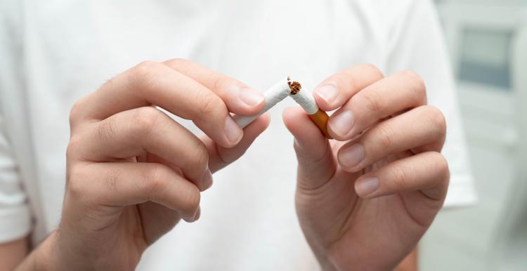 Person breaking a cigarette in two