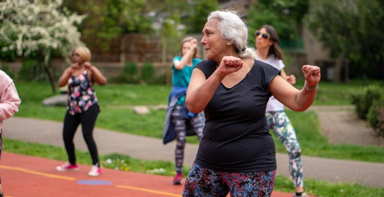 Older group of ladies exercising outdoors