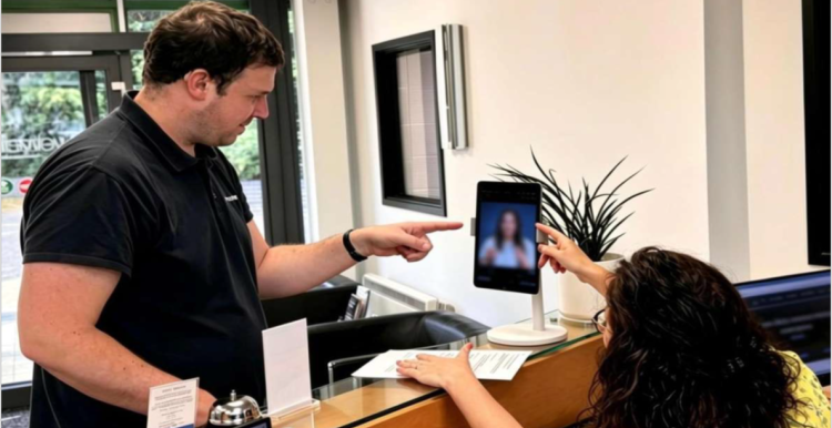 Deaf man points to a screen in a GP receptionist office