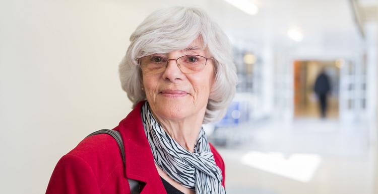 Woman smiling stood in a hospital corridor