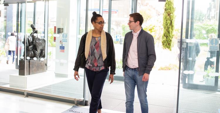 Two people walking in through main entrance of a hospital