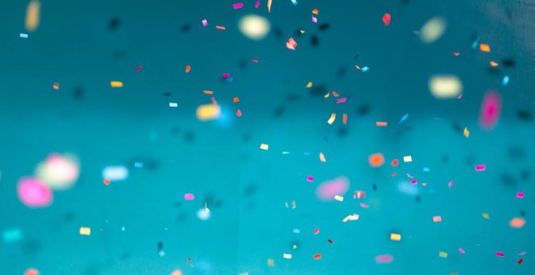 multi-coloured celebration confetti on blue background