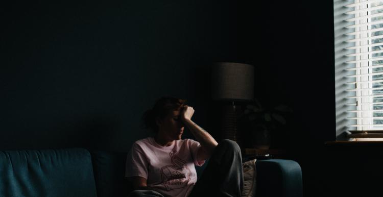 Person sitting on a couch in a dark room