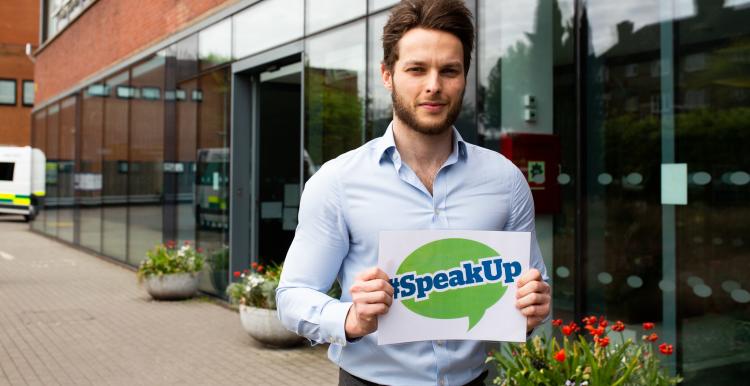 Man holding healthwatch speak up sign