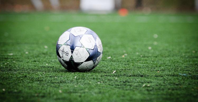 Image of a black and white football on a football pitch