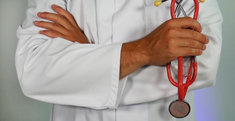 Doctor with arms crossed holding a stethoscope 