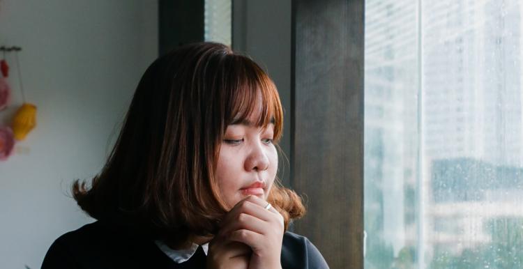 Woman sitting at a table looking out the window.