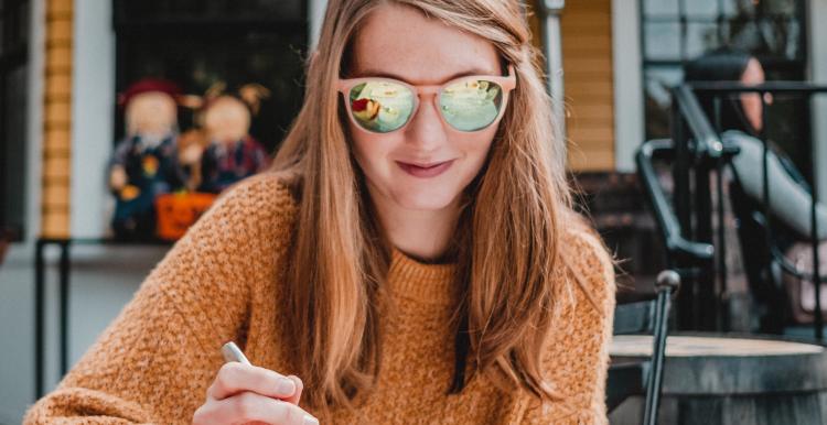 Woman with sunglasses eating outdoors