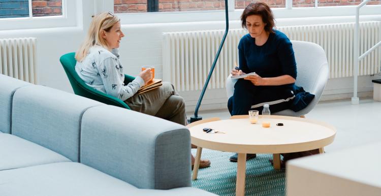 Two women talking in a modern office space