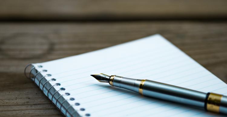 Notepad and fountain pen on a table