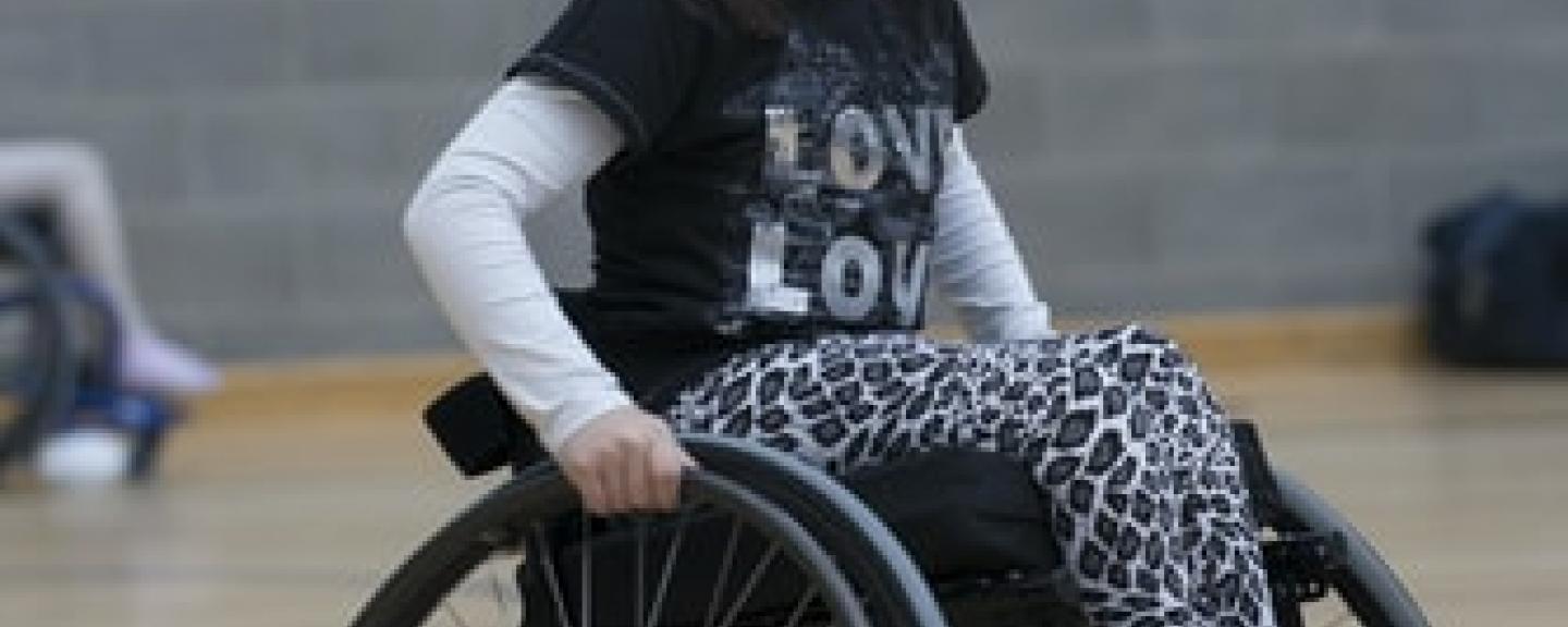 child smiling using a wheelchair