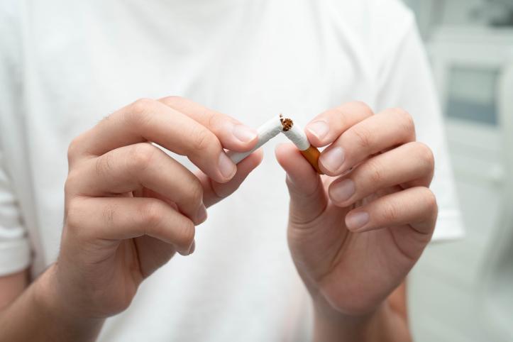 Person breaking a cigarette in two