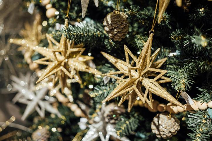 Gold stars hanging on a pine Christmas tree