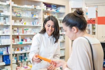 Pharmacist assisting a female customer at the counter