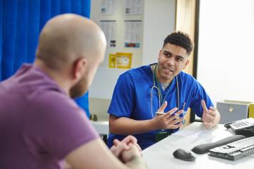 Male doctor talking to a man in a consultation room