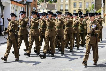 Group of soldiers marching in uniform in a British town