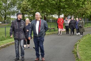 Group of people walking in a park range of ages and nationalities