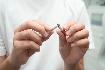 Person breaking a cigarette in two