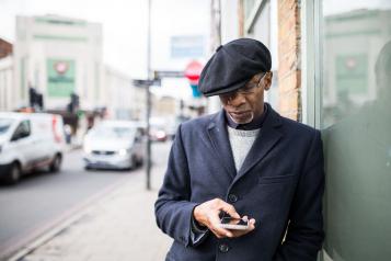 Man leaning against a wall on his mobile phone