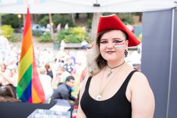 White woman at a park wearing a red hat smiling at camera