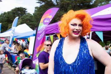 Person celebrating pride with brightly coloured clothes and hair