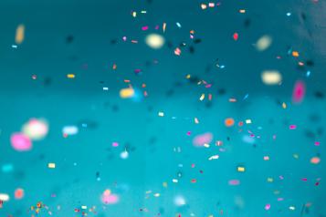multi-coloured celebration confetti on blue background