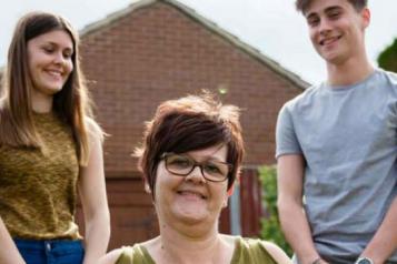 Mother with son and daughter in garden.