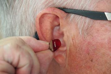 Man inserting a hearing aid