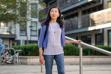 Woman walking down stairs outside holding the handrail