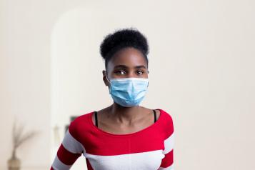 Young female in red and white top wearing a mask