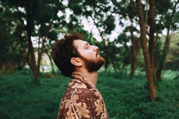 Man breathing deeply in a green space