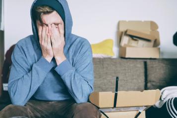 a person sitting at a table with their head in their hands