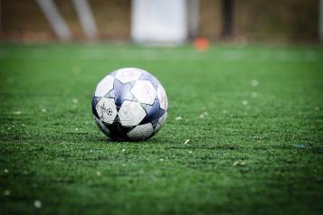 Image of a black and white football on a football pitch