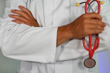 Doctor with arms crossed holding a stethoscope 