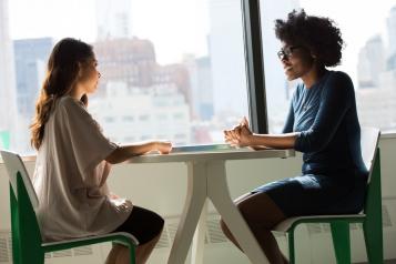 Two people sitting across a table in conversation