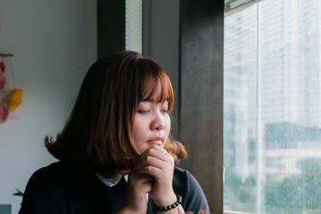 Woman sitting at a table looking out the window.