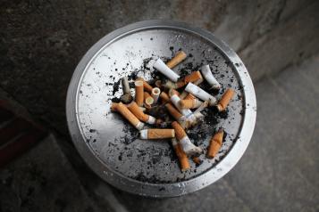 Image of silver ashtray with several stubbed out cigarettes