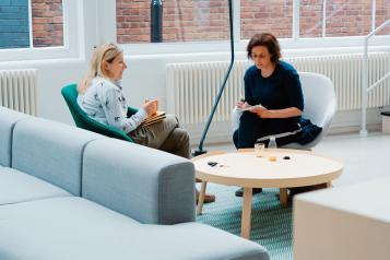 Two women talking in a modern office space