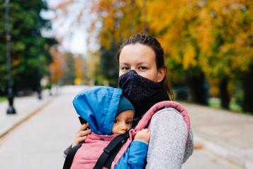 Mother wearing a face mask holding their baby