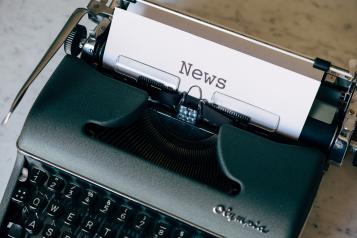 Old typewriter with News typed on white paper