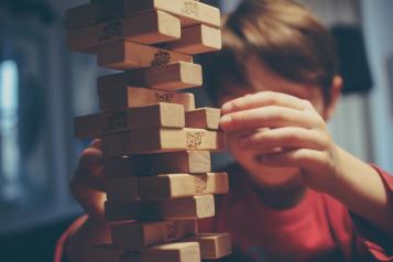 Image of young boy concentrating on Jenga block placement