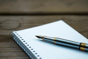 Notepad and fountain pen on a table