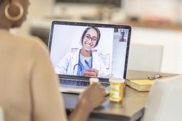 Female doctor having a video consultation with a patient on laptop