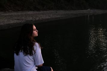 woman sitting looking at water