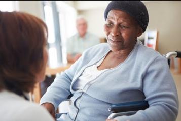 Black elderly woman in a nursing home talking to a nurse