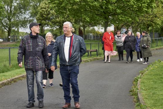 Group of people walking in a park range of ages and nationalities