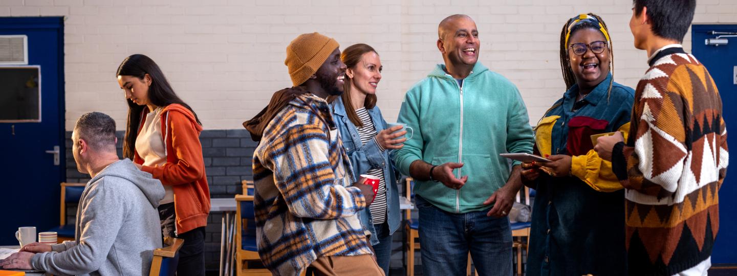 Diverse group of people standing and talking in a community hall