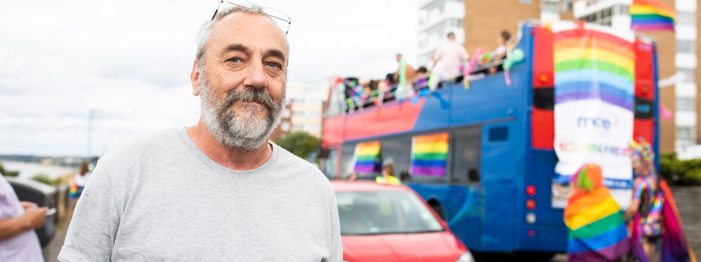 Man standing outside in front of an open air bus